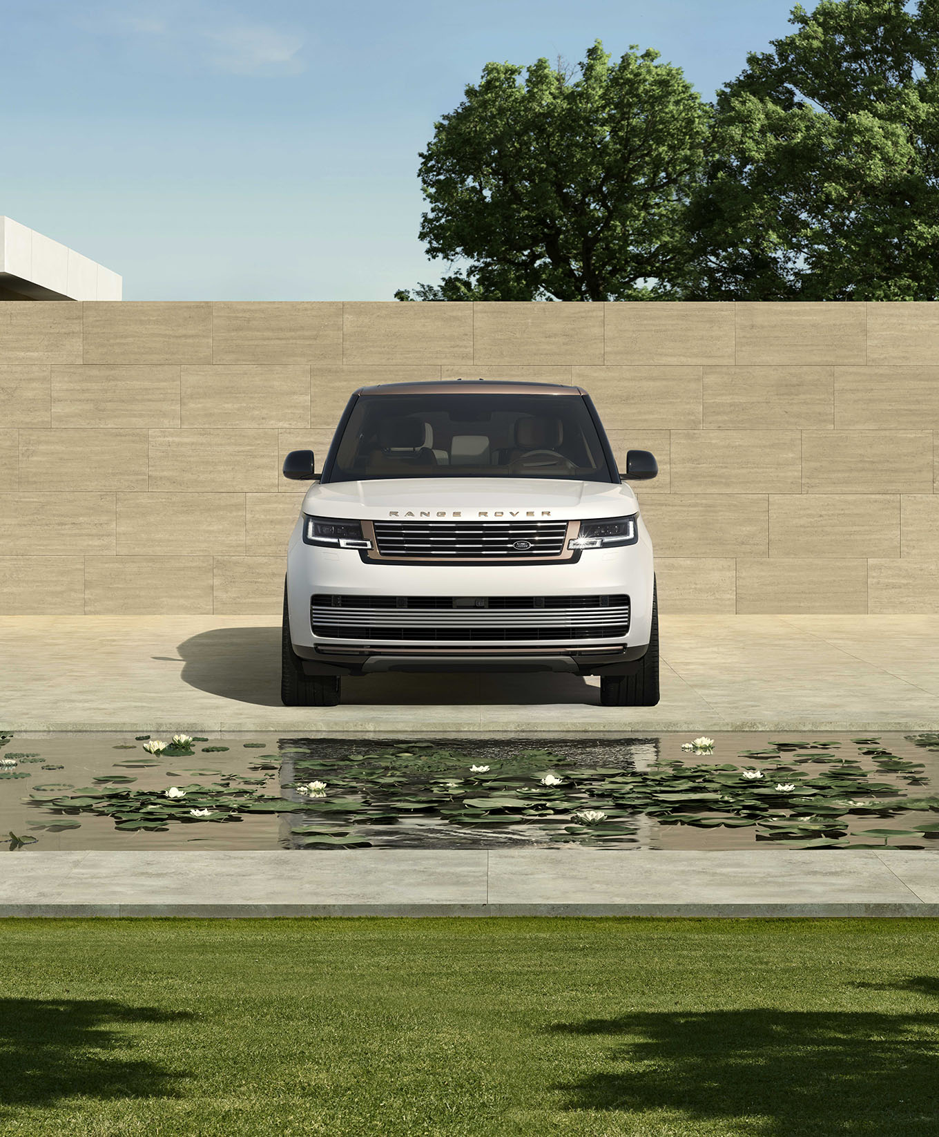 range rover in front of a pool with brick wall in background