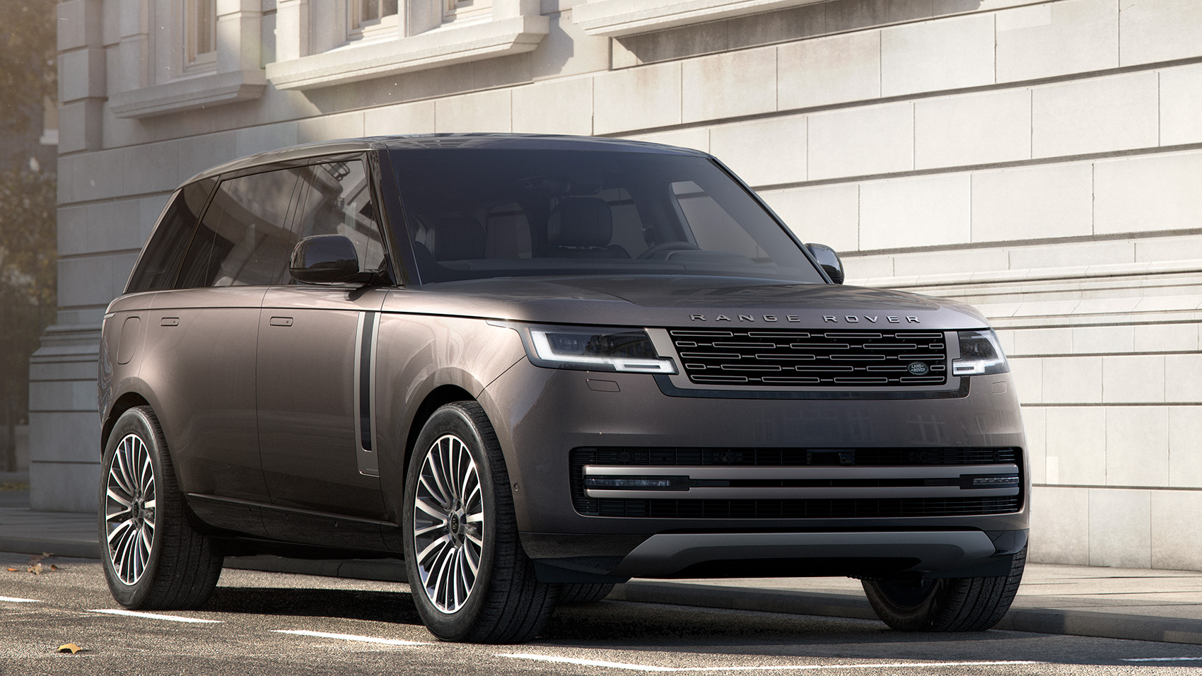 A Range Rover parked on a city street beside a stone building
